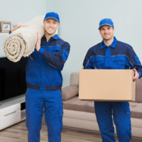 Packoutz franchise employees carry boxes and carpet